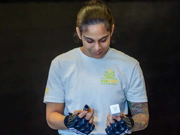 Atleta brasileira Livinha Souza segurando óleo de Canabidiol.