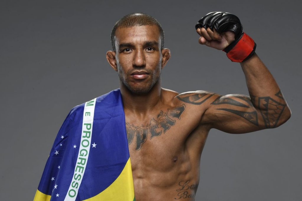 Lutador peso-galo do UFC brasileiro Raoni Barcelos com a bandeira do Brasil.
